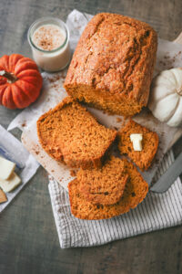 Slices of homemade pumpkin eggnog bread showing a moist, tender texture and warm pumpkin color, perfect for fall baking.