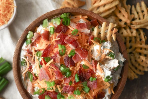Loaded baked potato dip made with sour cream, cheddar cheese, bacon, and chives