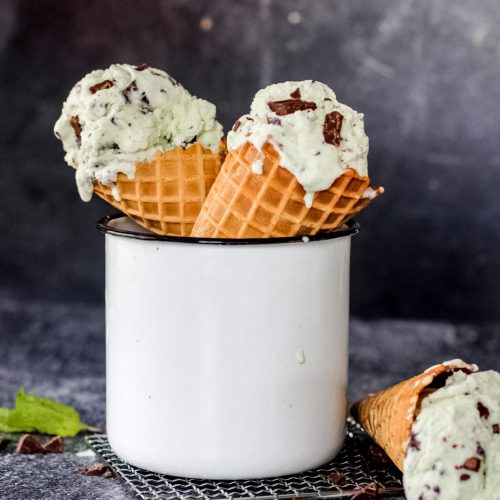 Homemade mint chocolate chip ice cream in a cone with chocolate chip
